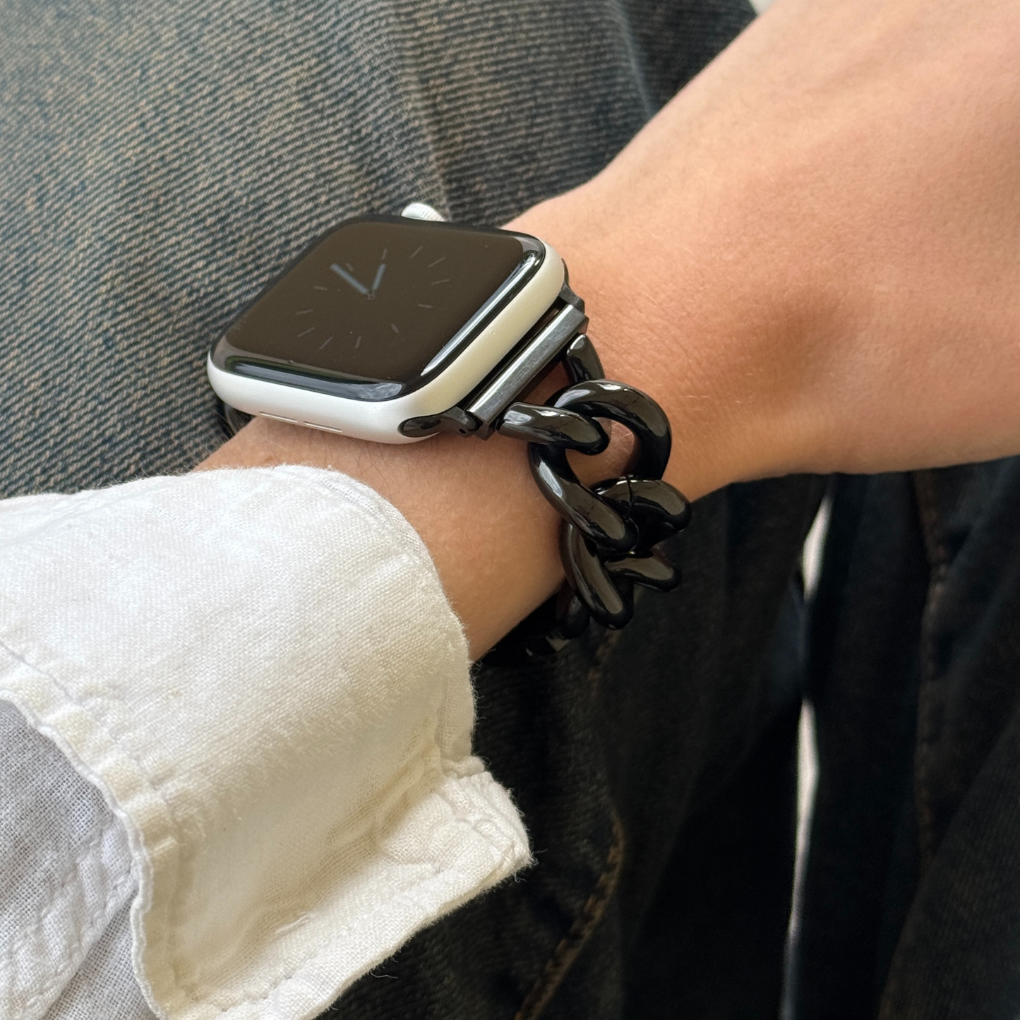 Smartwatch on a wrist with a chain strap, close-up view.