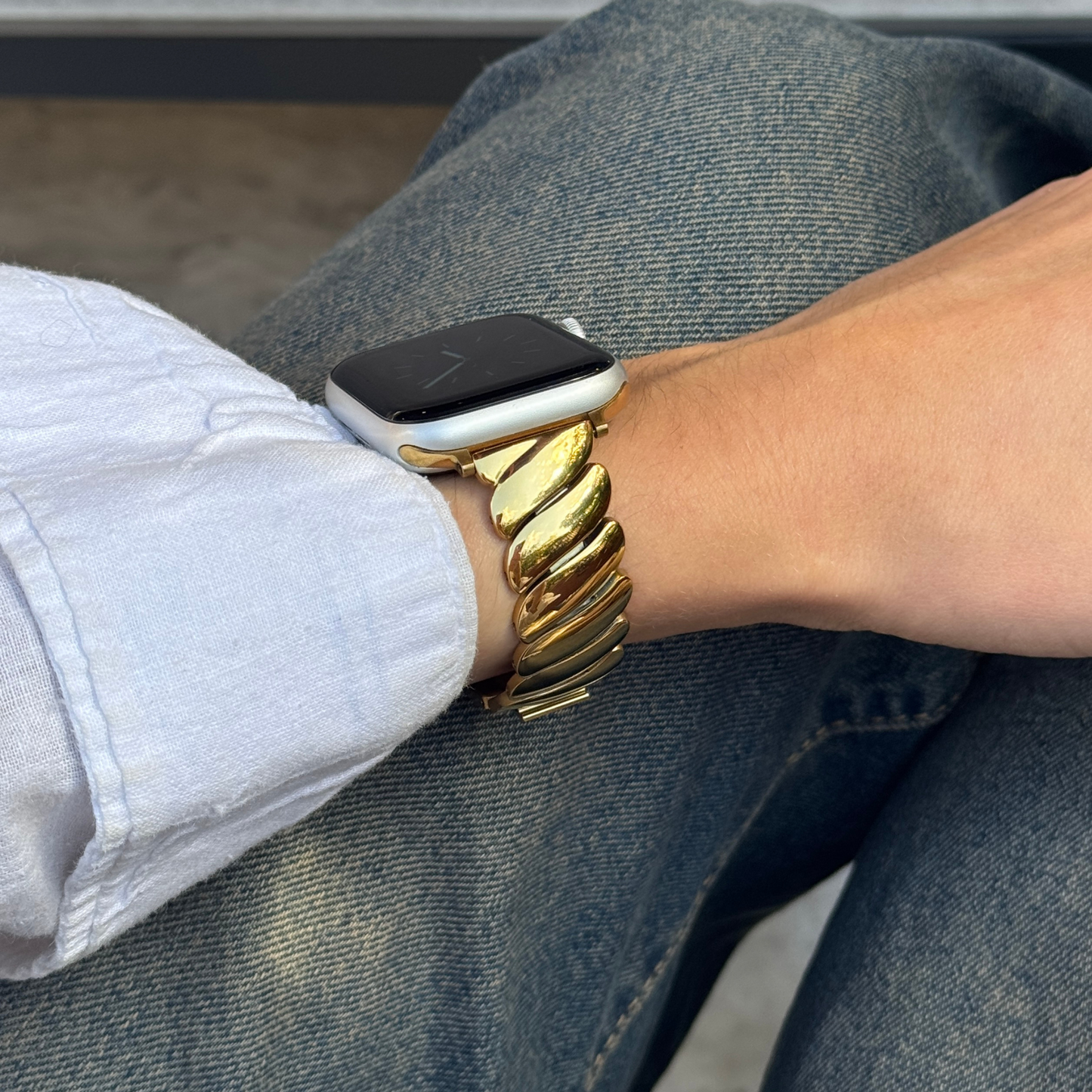 Person wearing a gold watch and smartwatch on a blurred background