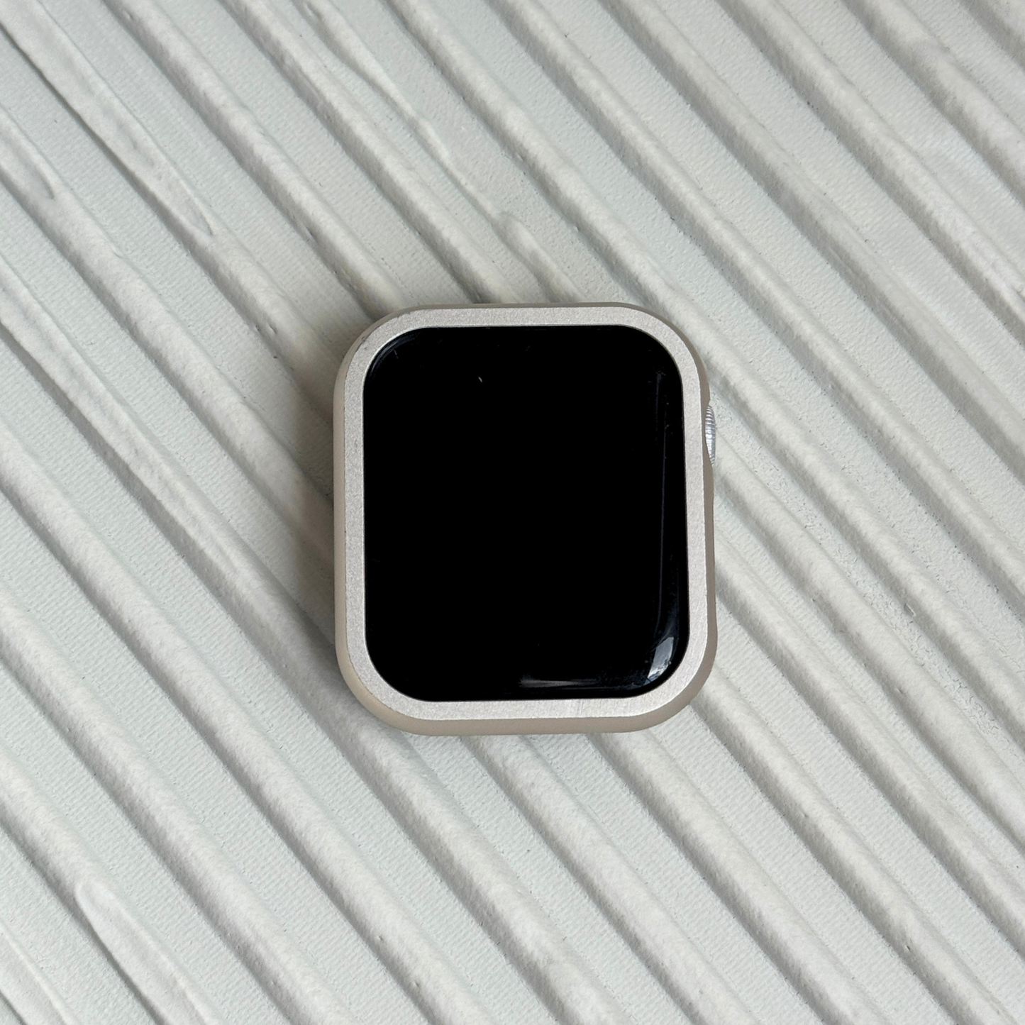 Smartwatch on a textured light gray surface with a Metal stainless steel apple watch case cover