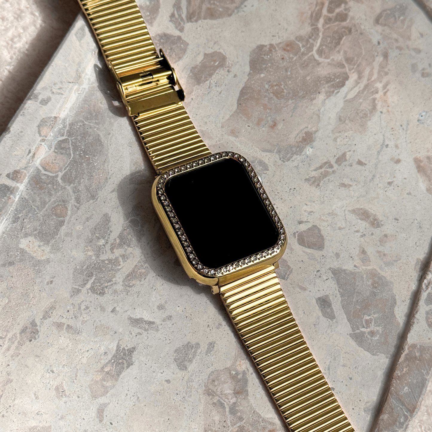 Gold apple watch with a black screen on a marble surface, Gold rhinestone apple watch case