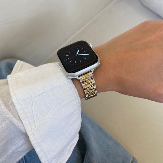 Silver gold woven link Apple Watch band worn with a white linen cuff over denim, stainless steel strap for Apple Watch 38mm to 49mm