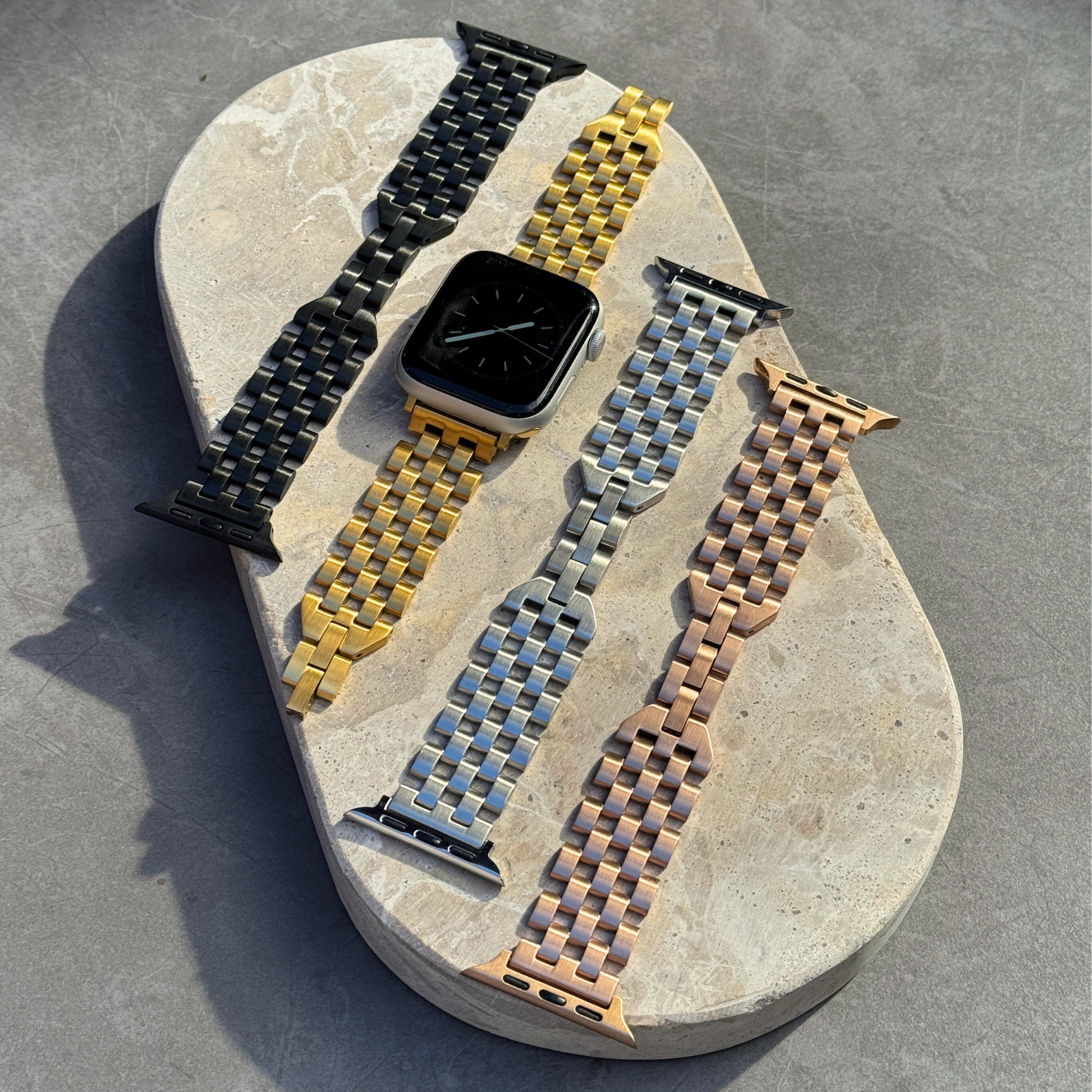 Collection of woven watch straps on a stone surface
