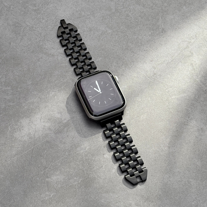 Black smartwatch with a metallic band on a gray textured surface