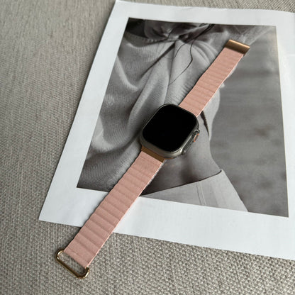 Smartwatch with a pink band on a textured surface